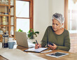 © Tamani Chithambo/peopleimages.com - Senior woman, budget planning and health insurance checklist with phone at home. Writing, contract and elderly female person with financial, tax and pension form in a house with bills and debt