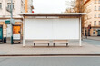 © ADDICTIVE STOCK - AI generated illustration of bus stop with empty advertising banner and benches placed on cobblestone pavement on city street