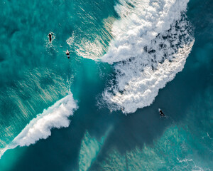 Wall Mural - Aerial view of the ocean with surfers, wave and nice pristine blue water