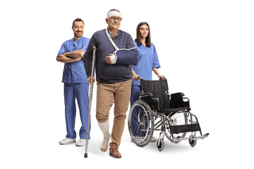 Wall Mural - Healthcare workers in blue uniforms with a wheelchair and a mature male patient with a crutch and arm sling