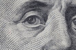 eye of Benjamin Franklin on one hundred US dollars banknote