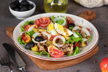 French Salad Nicoise With Tuna, Boiled Potatoes, Egg, Black Olives, Tomatoes, Onion And Lettuce Poured Balsamic Sauce, Close-up