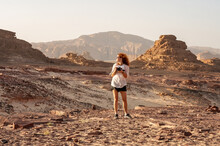Young Red Haired Girl With Camera In Hands In The Rocky Desert Sinai Egypt