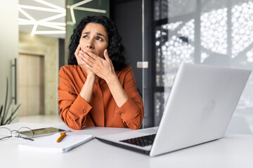 Boring and boring job business woman yawning at workplace, latin american woman with curly hair working inside office at workplace with laptop, overtired and sleepy worker.