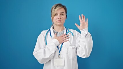 Poster - Young blonde woman doctor making an oath with hand on chest over isolated blue background