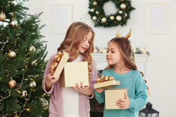 Wall Mural - Cute little girls opening Christmas gifts at home