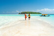 © robertharding - Man and woman in love holding hands walking on empty sandy shore surrounded by the Indian Ocean, Zanzibar, Tanzania