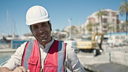 Wall Mural - Young hispanic man builder smiling confident standing at street