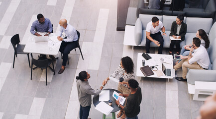 Top view, businesspeople talking and meeting at a conference at their office space. Diversity at work, communication or collaboration and networking or event planning have a conversation together