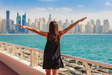 Tourist woman in Dubai, UAE. Palm trees and skyscrapers. Sunny summer