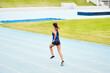 © Emil Lime/peopleimages.com - Woman, back and running on stadium track in fitness, exercise or workout for cardio training outdoors. Fit, active or sporty female person, runner or athlete sprinting competition, exercising or race