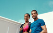 © Emil Lime/peopleimages.com - Fitness, portrait of happy woman and man with blue sky, mockup at outdoor gym for health and wellness in sports. Workout, exercise and personal trainer with athlete, smile and healthy mindset goals.