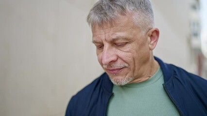 Poster - Middle age grey-haired man standing with serious expression at street