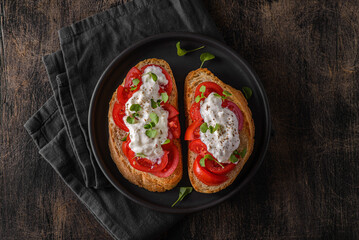 two bruschetta with tomatoes on a wooden background