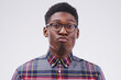 Funny face, young and portrait of a black man pouting isolated on a white background in a studio. Geek, pout and a face headshot of an African person with glasses as a nerd, goofy and quirky