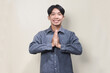 Young Asian man wearing casual shirt with greeting and welcoming gesture