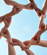 © L De Bruin/peopleimages.com - Hands, chain and circle with team and blue sky with low angle, solidarity and trust with arm link and people together. Teamwork, motivation and connection with group collaboration and community