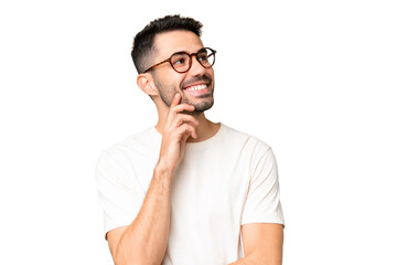 Wall Mural - Young handsome caucasian man over isolated chroma key background thinking an idea while looking up