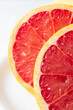 © Arantxa Forcada - Macro close up of half a red grapefruit with selective focus, white background, vertical