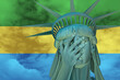 Statue of Liberty. Facepalm emoji on background in colors of Gabon flag