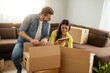 © ivanko80 - Smiling couple unpacking boxes in new home