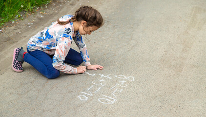 Wall Mural - Children draw equations on the pavement with chalk. Selective focus.