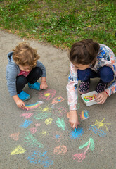 Wall Mural - Children draw with chalk on the pavement. Selective focus.