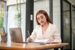 © Wasana - Asian businesswoman sitting in front of her considering work, office work Business woman sitting thinking work concept, Write a plan