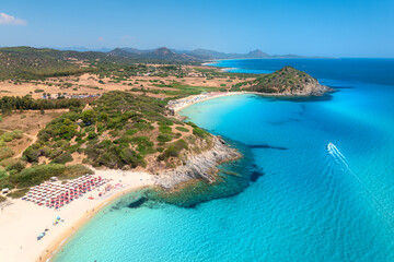 Sticker - Aerial view of white sandy beach, umbrellas, mountains, green trees, yacht in blue sea at sunset in summer. Tropical landscape. Travel in Sardinia, Italy. Top view of ocean with transparent water