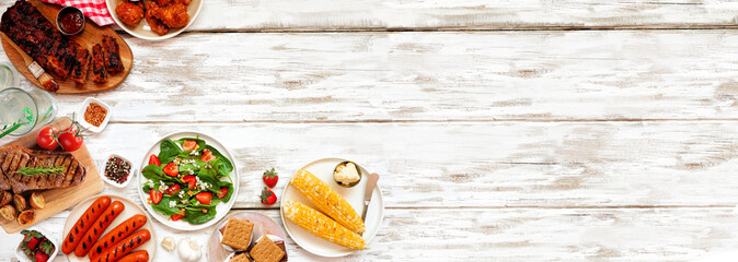 Summer BBQ food corner border over a white wood banner background. Variety of grilled meats, vegetable dishes and smores. Top down view with copy space.