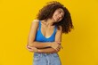 © SHOTPRIME STUDIO - Woman with curly afro hair in a blue t-shirt on. yellow background signs with her hands, look into the camera, smile with teeth and happiness, copy space