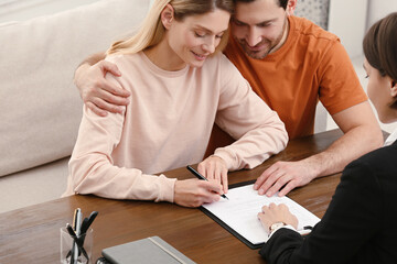 Wall Mural - Notary helping couple with paperwork at wooden table, closeup