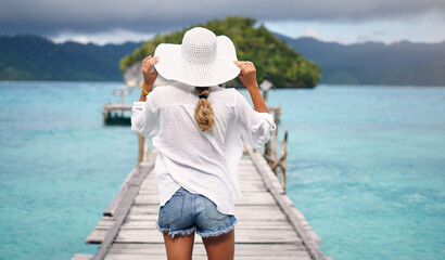 Sticker - Island, ocean and back of woman on deck for holiday, summer vacation and weekend getaway in Maldives. Traveling, tropical villa and female person on luxury resort for relax, happiness and adventure