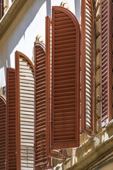 Wall Mural - Arched wooden shutters on a building near Santa Croce Basilica, Florence, Italy