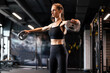© ty - Muscular fit woman exercising building muscles at gym. Upper body training.