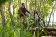 © Wavebreak Media - Happy biracial couple wearing backpacks, hiking and holding hands in forest