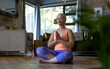 © Wavebreak Media - Tranquil unaltered biracial woman practicing yoga meditation sitting in living room at home