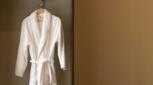 Hanger with clean white bathrobe in hotel wardrobe