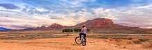 Woman On Bike Enjoying Panoramic View Of Countryside Land And Mountain (Aragon, Spain)