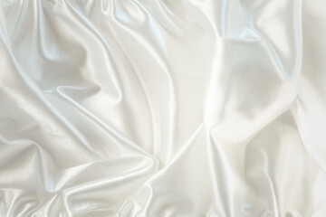 Abstract white textile background. Snowy white satin or silk fabric in waves. Fabric folds.