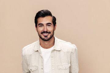 Portrait of a stylish man smile closeup on a beige background in a white t-shirt, fashionable clothing style, copy space