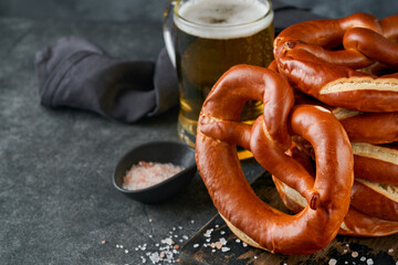 Wall Mural - Oktoberfest concept card. Traditional Bavarian pretzels with beer bottle mug on old dark black rustic background. Perfect for Octoberfest. Oktoberfest food menu.