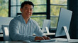 © Yuliia - Mature Asian businessman chinese korean office worker specialist male work on computer develop project online look at camera confident smile. Portrait successful senior man business profession concept