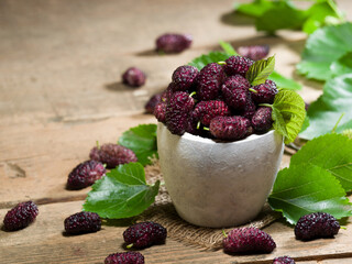 Fresh purple berries in rustic bowl. purple summer fruits