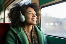 A Afro American Woman Sitting On A Train With Headphones On