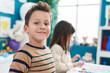 © Krakenimages.com - Adorable boy and girl smiling confident sitting on table at kindergarten