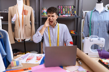 Poster - Young hispanic man dressmaker designer using laptop clueless and confused with open arms, no idea and doubtful face.