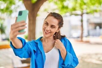 Sticker - Young woman smiling confident making selfie by the smartphone at park