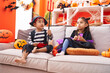 © Krakenimages.com - Adorable boy and girl having halloween party sitting on sofa at home