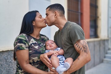 Wall Mural - Hispanic family hugging each other and kissing at street